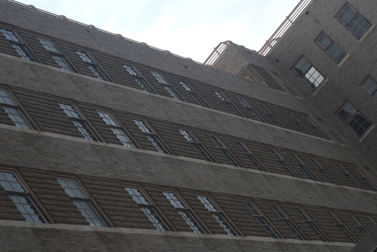 View of brick wall with many windows.