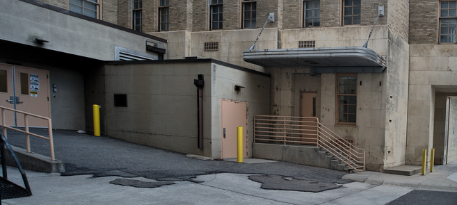 A newer loading dock next to an art deco cannopied entry